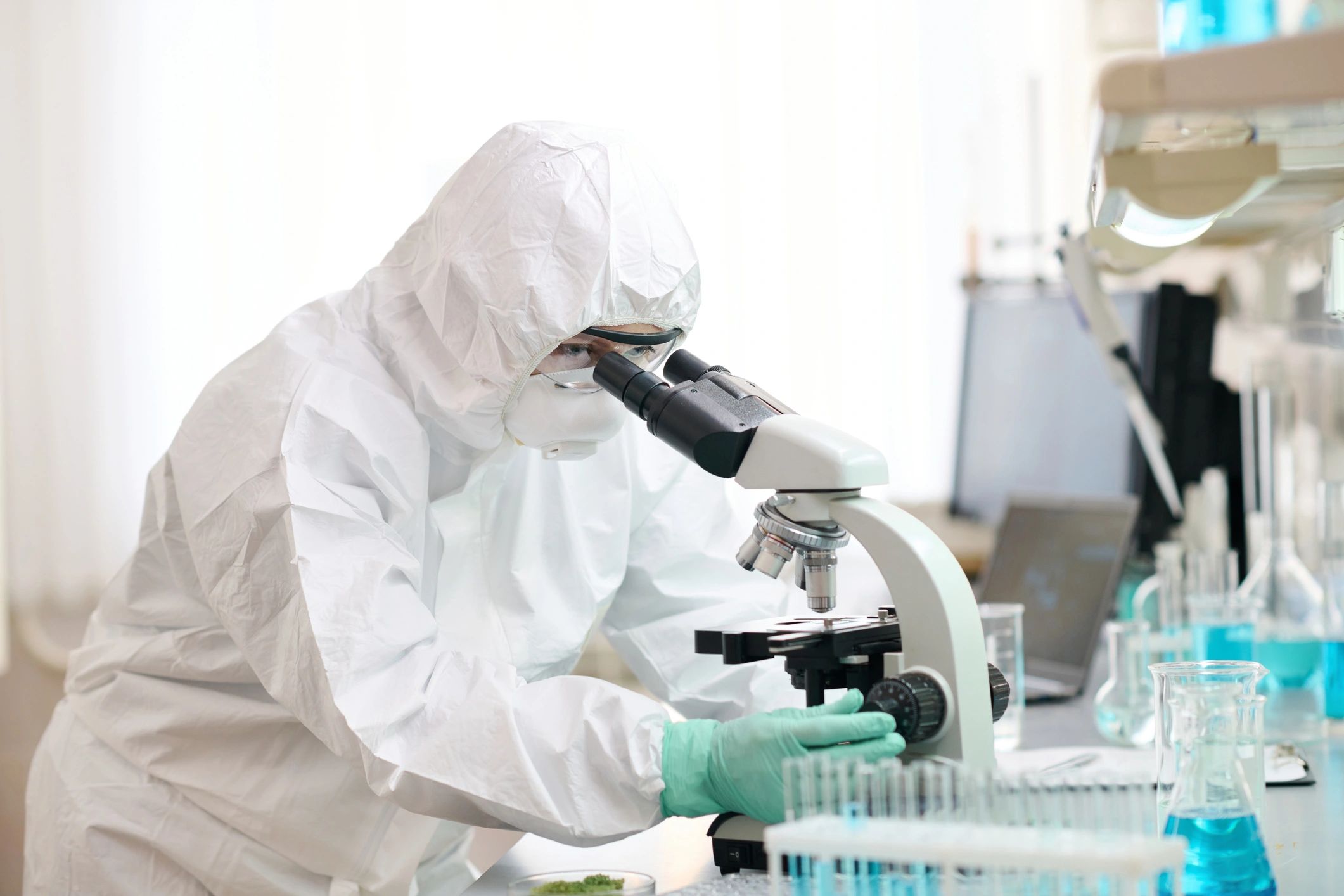 Scientist using microscope in a diagnostic laboratory